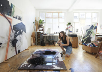 Eine junge Künstlerin malt in ihrem Atelier