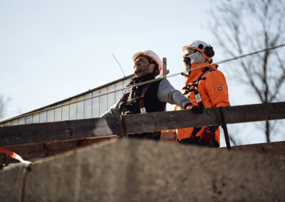 Bauarbeiter arbeiten auf einem Brückenstahlträger