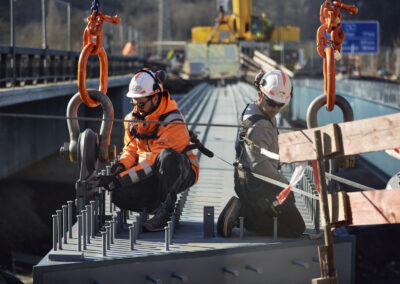 Bauarbeiter arbeiten auf einem Brückenstahlträger